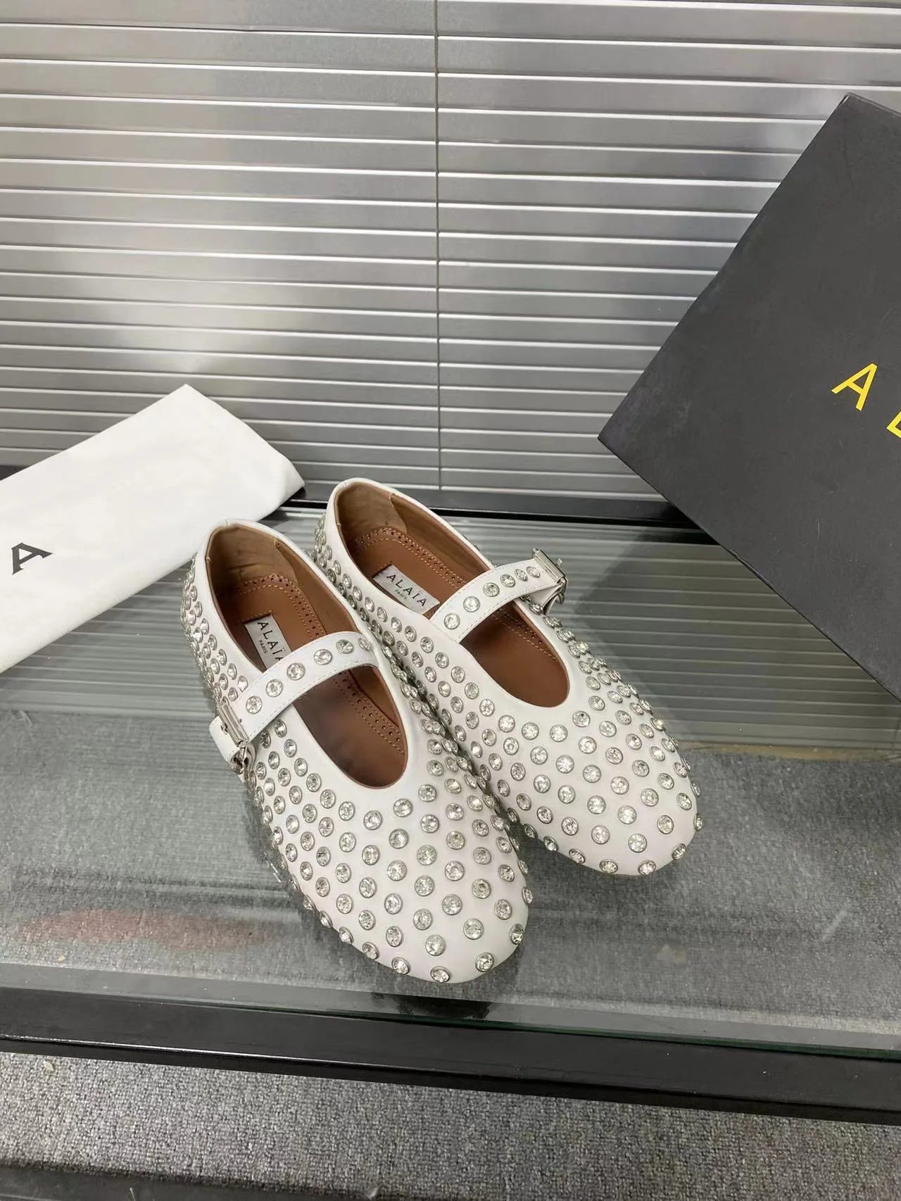 Alaia Cowhide Sheepskin Glossy Round-Toe Buckle Studded Mary Jane Flats in White · view 1