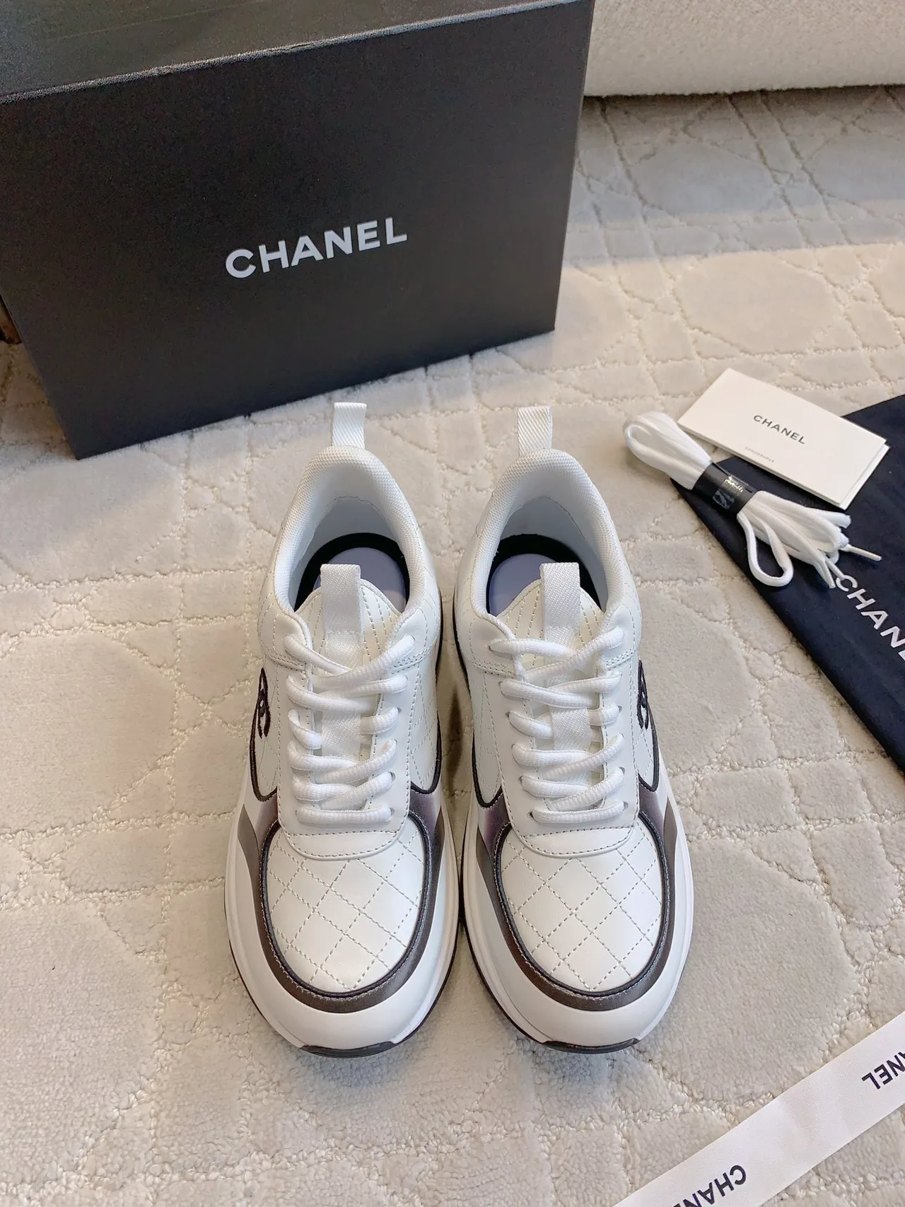 Chanel Quilted Sneakers in White · view 1