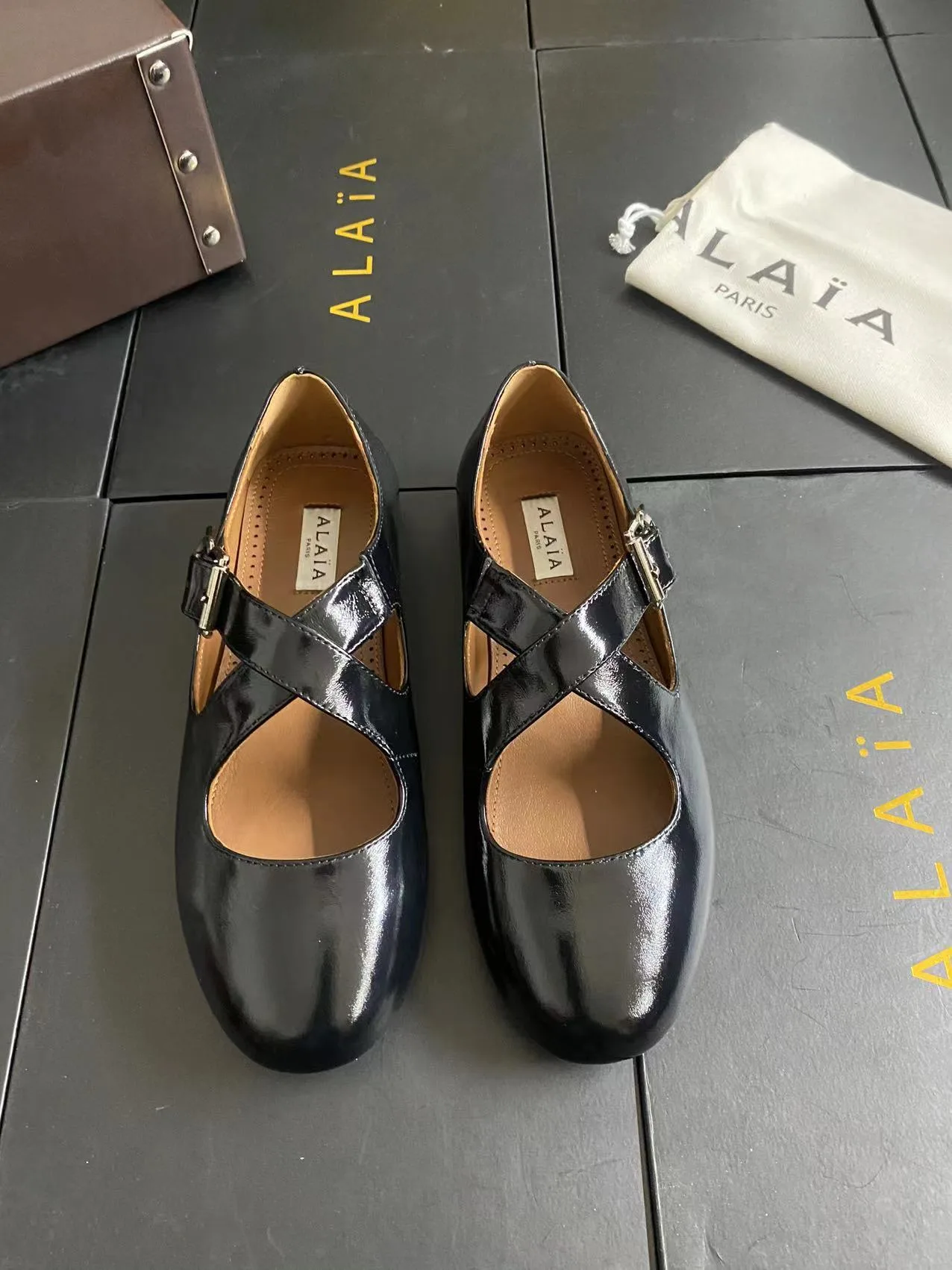 Alaia Cowhide Sheepskin Glossy Square-Toe Buckle Cross-Strap Flats in Black · view 1